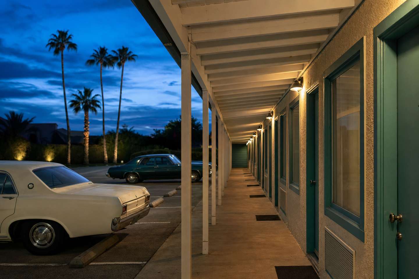 A classic roadside motor-inn exterior at dusk with warm porch lights (AI-generated image)